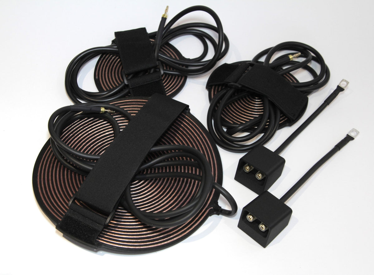 Overhead view of the full kit laid out: coils, pads, connection boxes and ring terminal leads
