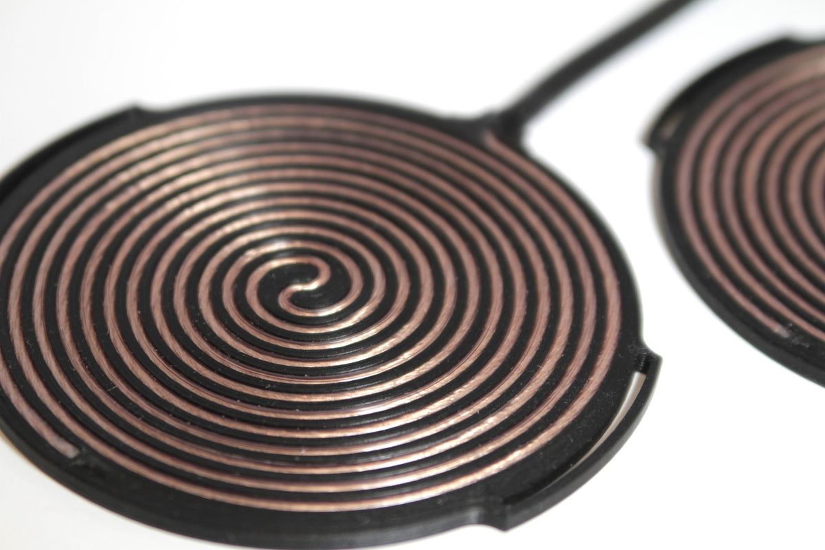 Close-up of the Tvíburi pad copper spiral winding seated in its printed TPU groove